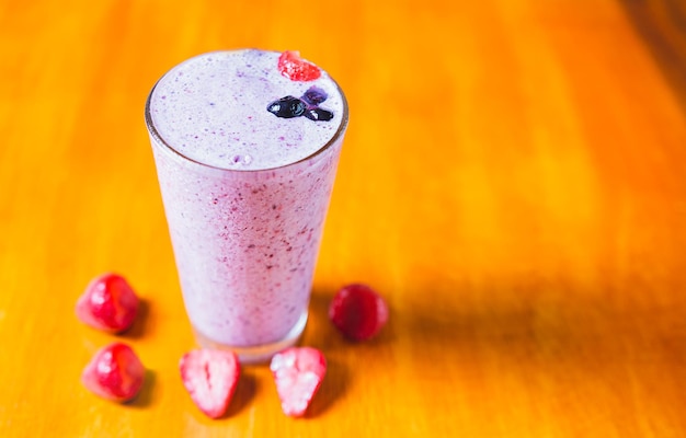 Strawberry milkshake on wooden table Strawberry smoothie with blueberry on wooden background