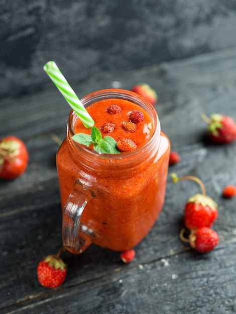 Strawberry red summer smoothie on stone background