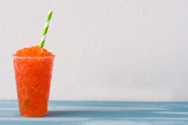 Strawberry slushie on blue wooden table 