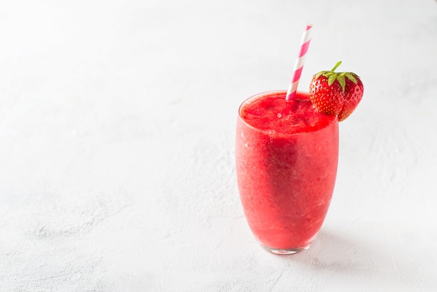 Strawberry smoothie and fresh raw berries on white