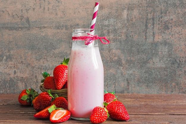 Strawberry smoothie or milkshake in a bottle with straw