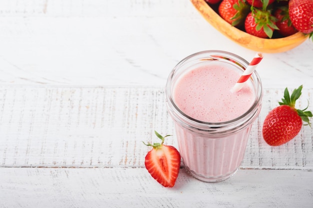 Strawberry smoothie Vegan smoothie or milkshake from strawberry banana and mint on white wooden table background Clean eating alkaline diet Top view Mock up