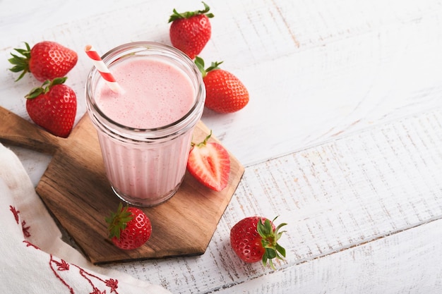 Strawberry smoothie Vegan smoothie or milkshake from strawberry banana and mint on white wooden table background Clean eating alkaline diet Top view Mock up