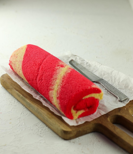 Strawberry Sponge Roll served on a wooden plate