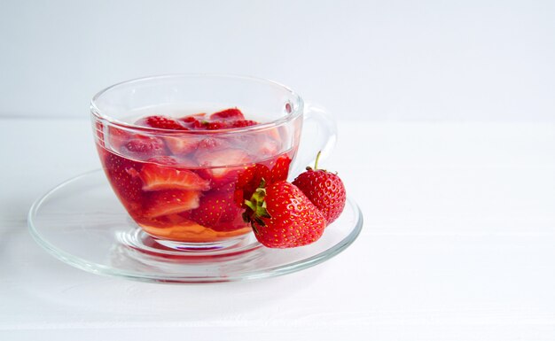 Strawberry tea in a transparent cup isolated on white background