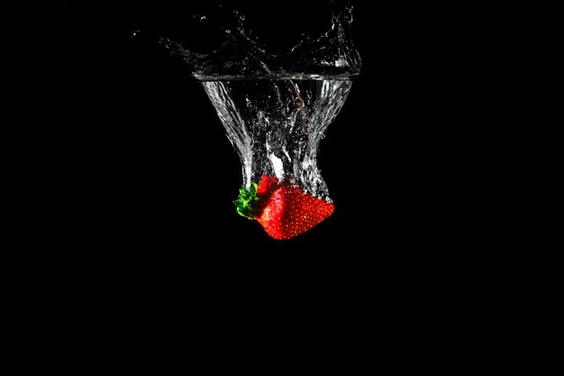 Strawberry in water with black background