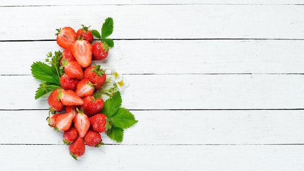 Strawberry with leaves on a white wooden background Berries Top view Free space for your text