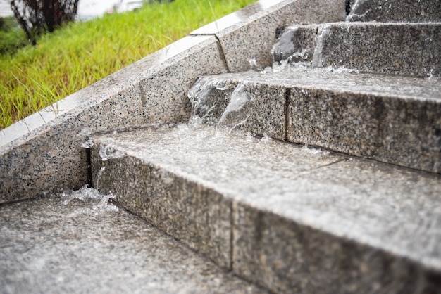 The stream of water flows down from the steps of the stairs. Heavy rain. Rainy fall weather.