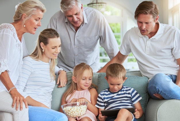 Streaming media and family watch tablet movies entertainment on internet mobile app together in living room Happy family people love watching online reunion film series on technology in home lounge