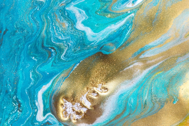 Streams of liquid blue white and gold ink curls waves of fluid turquoise and golden fluid paint