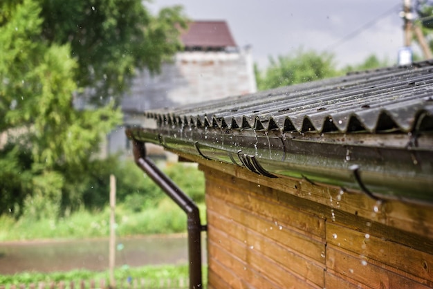 Streams of rain are flowing down from the roof