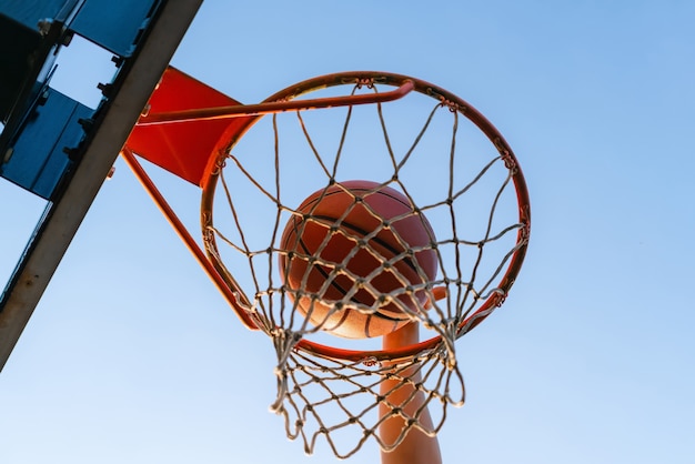 Street basketball slam dunk competition, close up of ball falling into the hoop.