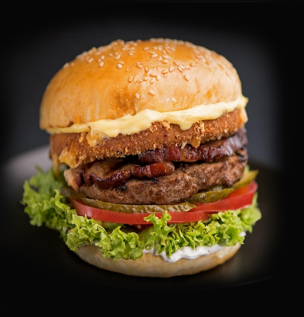 Street food fast food Homemade juicy burgers with beef cheese and onions on a black background