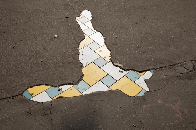 street hole in the sidewalk of the city repaired by an artist with tiling mosaic street art from Lyon city in France