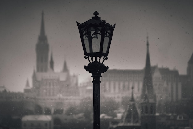 Street lamp in front of rising spires of Matthias Church and Szilбgyi Dezso Church in Buda on a snowy day Budapest Hungary