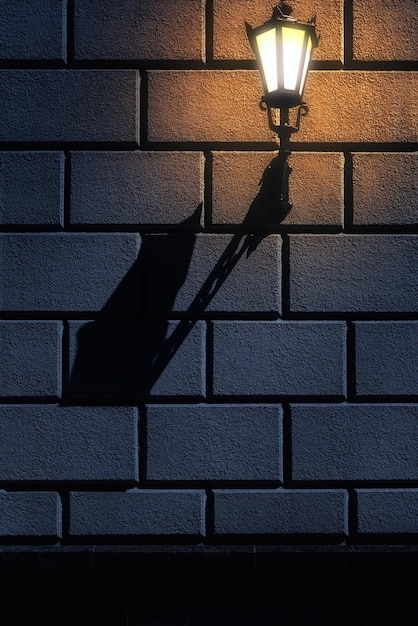 Street lantern on the stone block wall at night