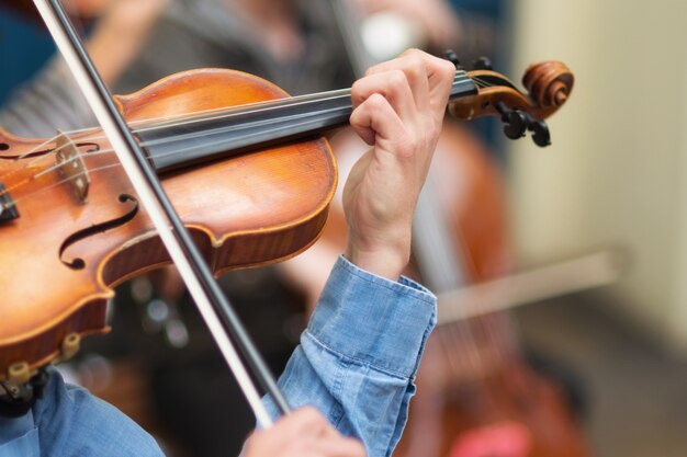 Photo street musician playing violin in the streets.