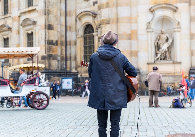 Street musician with a guitar in old European town.