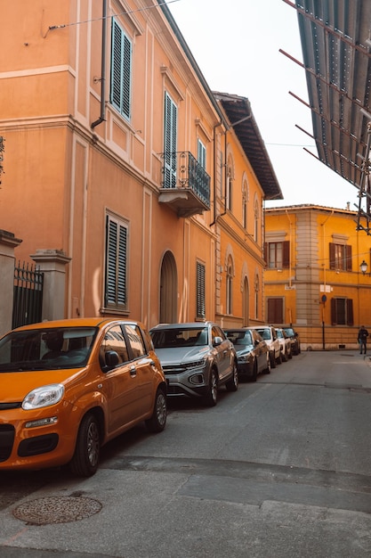 Street parking on the hill in old city The street with ancient buildings in the center of Pisa Italy Photo of the facades of old buildings in the historic center