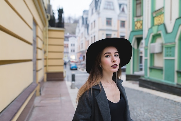 Street portrait of a stylish woman on the background of the street of an old beautiful town.