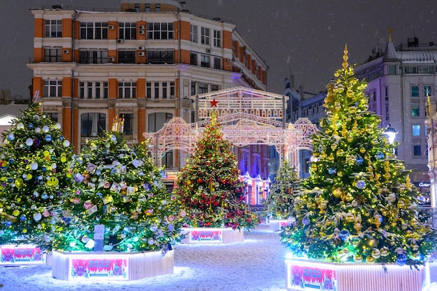 The streets of city decorated with christmas trees and garlands during New Year's Eve The snowstorm