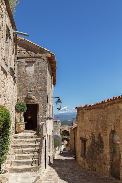 Streets of restored old village Lacoste under blue sky, Vaucluse, France