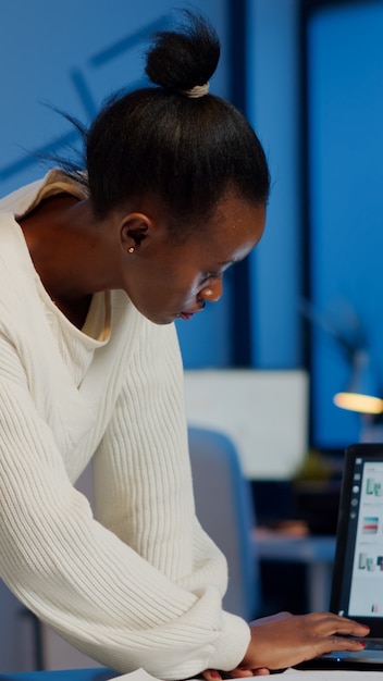 Stressed african manager woman working with financial documents checking graphs, holding papers