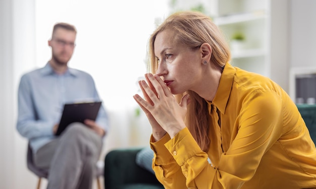 Stressed blonde woman at psychologist talking