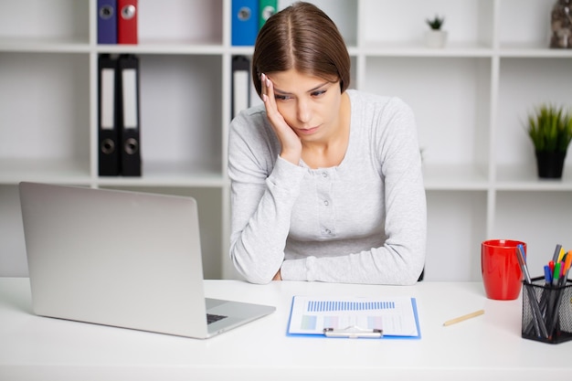 Stressed Business Woman Holding Her Head With Hand In Office