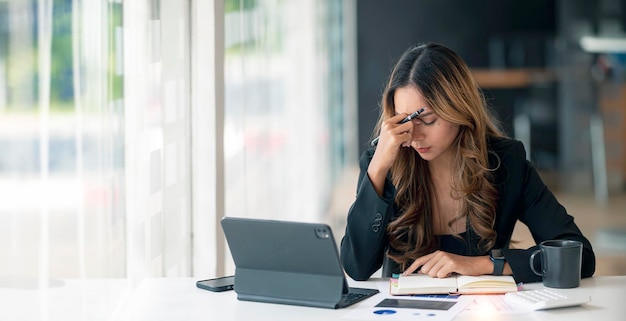 Stressed business woman working at office on laptop closed her eyes looking worried tired and overwhelmed