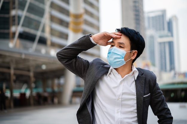 Stressed businessman with medical mask during coronavirus pandemic in the city