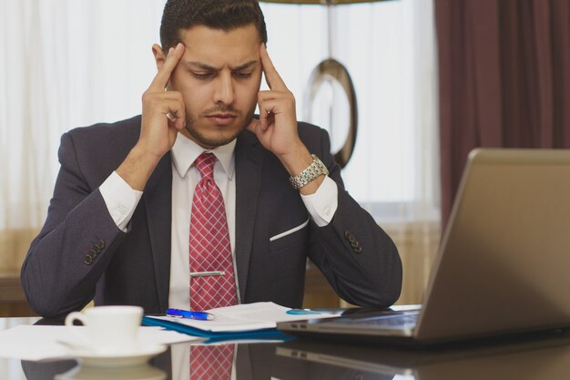 Stressed businessman working on his laptop