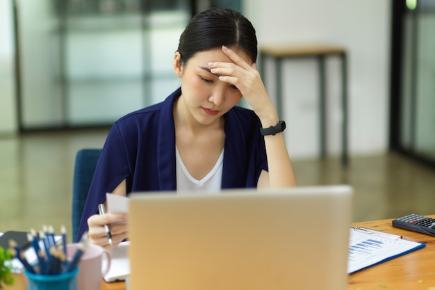 Stressed businesswomen working in office sit in front of laptop pensive thinking to solve problems