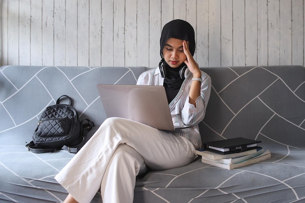 Stressed college student tired of hard learning with books and laptop. Exhausted with difficult stud