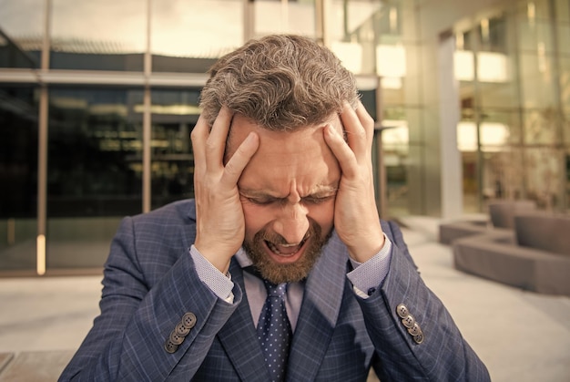 Stressed frustrated bearded businessman in formal suit rage