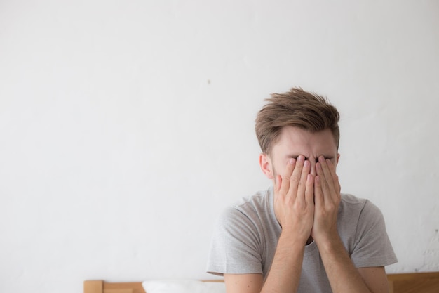 Photo stressed mid adult man sitting on bed at home