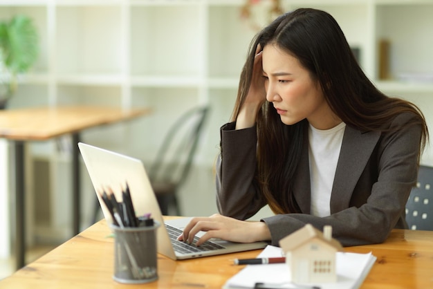 Stressed-out businesswoman is having IT problems with her laptop computer, is disappointed with the result of her work, and is looking for business solutions.