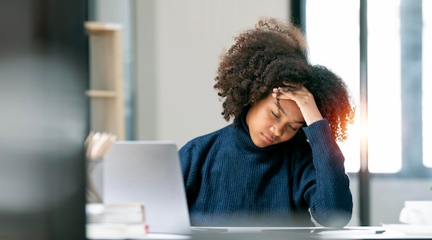 Stressed overwhelmed african businesswoman feels tired at work exhausted black female suffering from headache touching stress at work or migraine concept