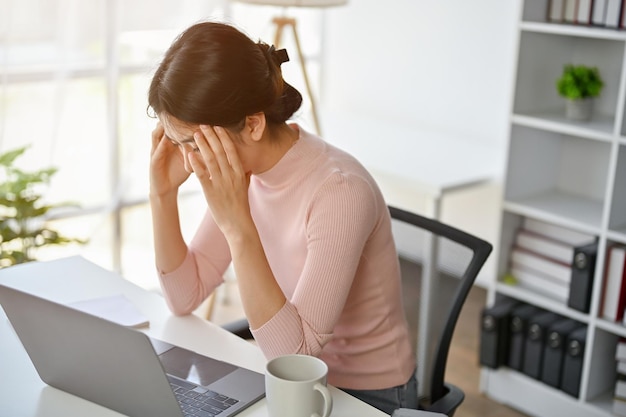 Stressed and serious Asian businesswoman worried about the project deadline