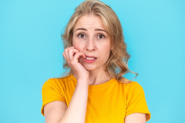 Stressed woman feels worried bites her fingernails