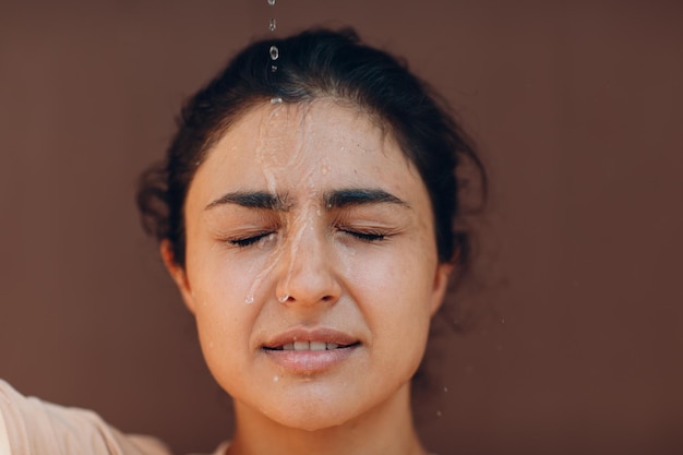 Stressed woman suffering of heatstroke refreshing with cold water outside Weather abnormal heat concept