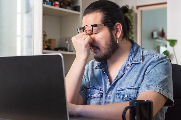 Stressed young man in front of the laptop