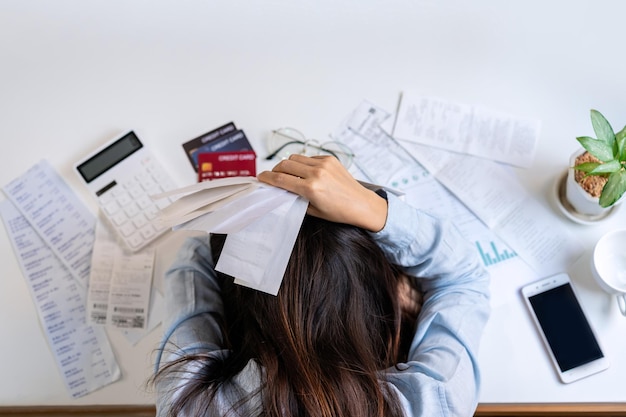 Stressed young woman calculating monthly home expenses, taxes, bank account balance and credit card bills payment, Income is not enough for expenses