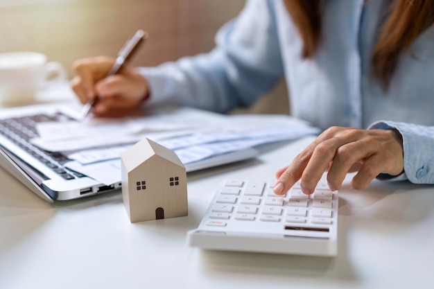 Stressed young woman calculating monthly home expenses