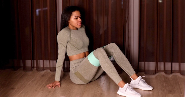 Stretch more. sporty woman in sportswear using elastic band for doing stretching exercises.