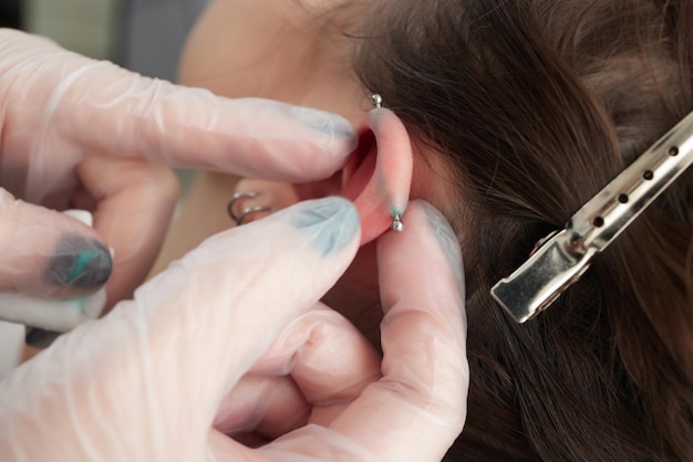 Stretched lobe piercing grunge concept Pierced woman ear with black plug tunnel industrial and rook