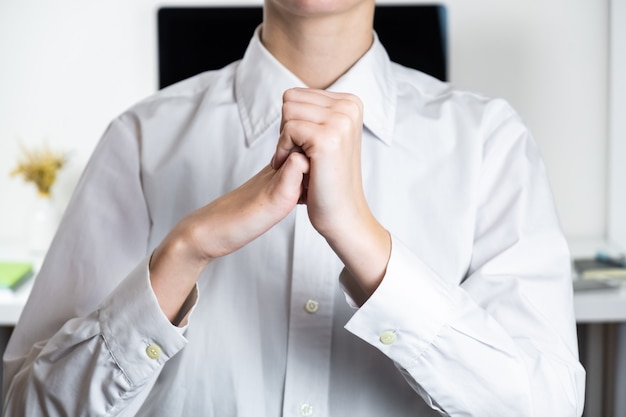 Stretching arms in sparse office workplace. Hands of an employee in front of modern desktop, tired of typing concept