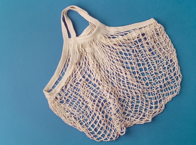 String bag on aquamarine background. Flat lay, top view. Zero waste and plastic free concept.