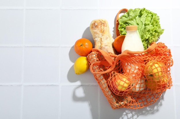 String bag with food on tile background