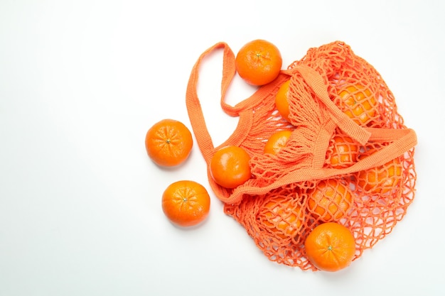 String bag with mandarins on white background